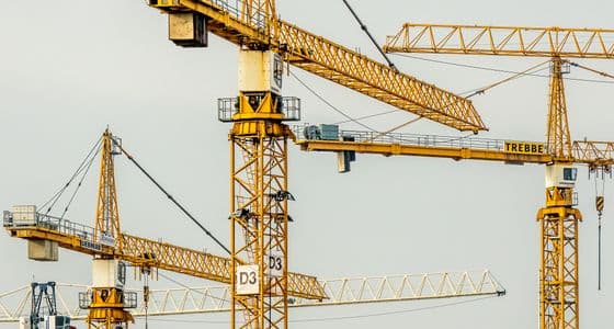 A construction site with tower cranes above a partially built structure