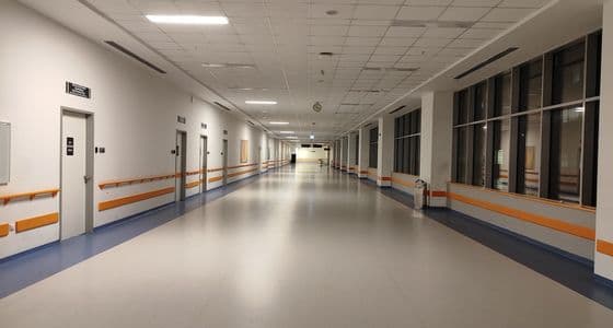 A bright, clean hospital corridor lined with handrails